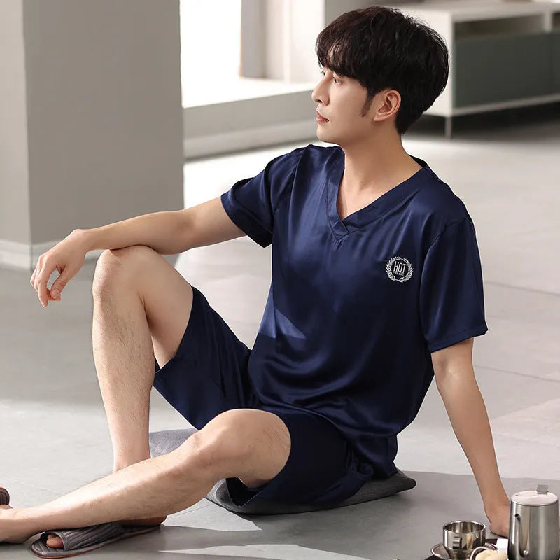 Man wearing a loose grey ice silk short-sleeve pyjama top and matching shorts.