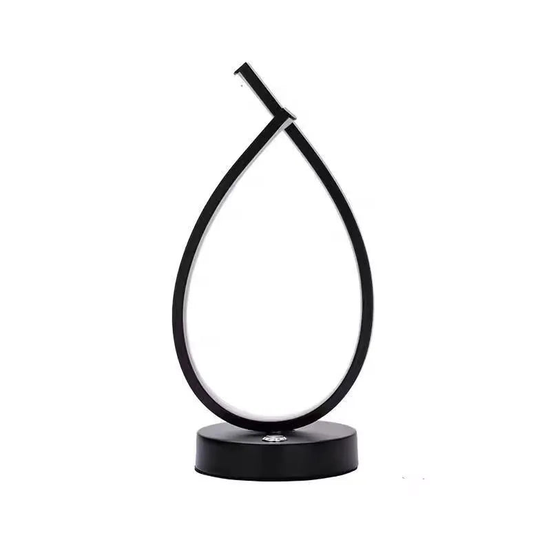 Black water drop shaped USB table lamp with touch control on wooden bedside table