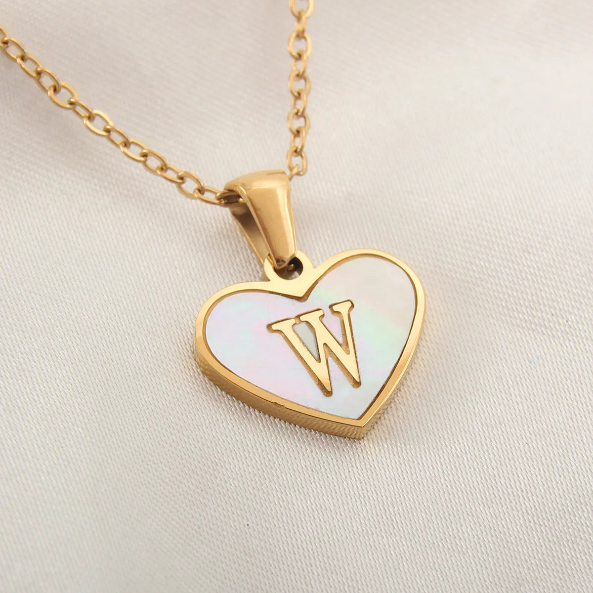 Gold plated chain necklace with a white shell heart-shaped pendant personalised with a single letter initial.