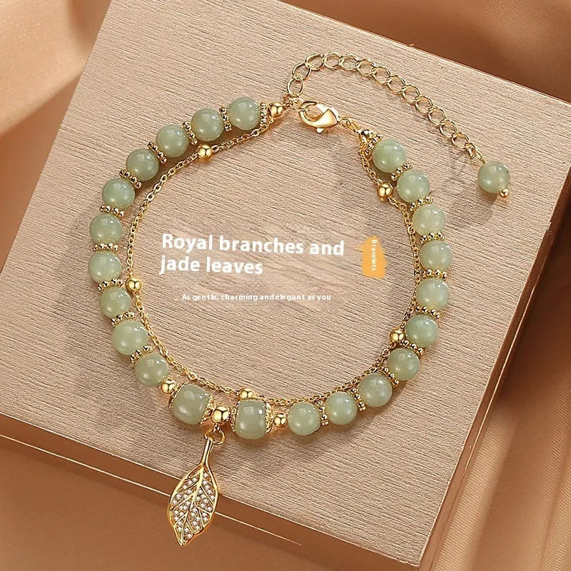 Chinese style glass bead bracelet with bamboo leaf design and manual craftsmanship details.