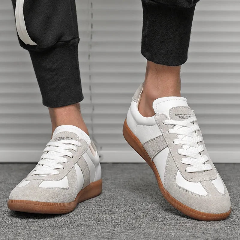 White Japanese-style retro low-top sneakers with round toe and flat rubber sole on a solid background.