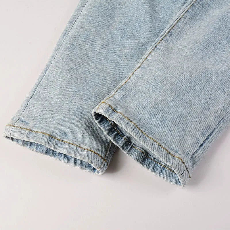 Light blue elastic tight fit jeans for men with patchwork and cat whisker finish