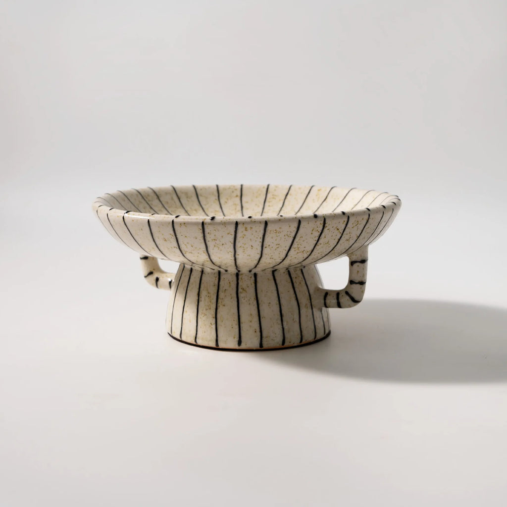 Black and white striped plastic resin fruit plate ornament, 16cm diameter, on a table.