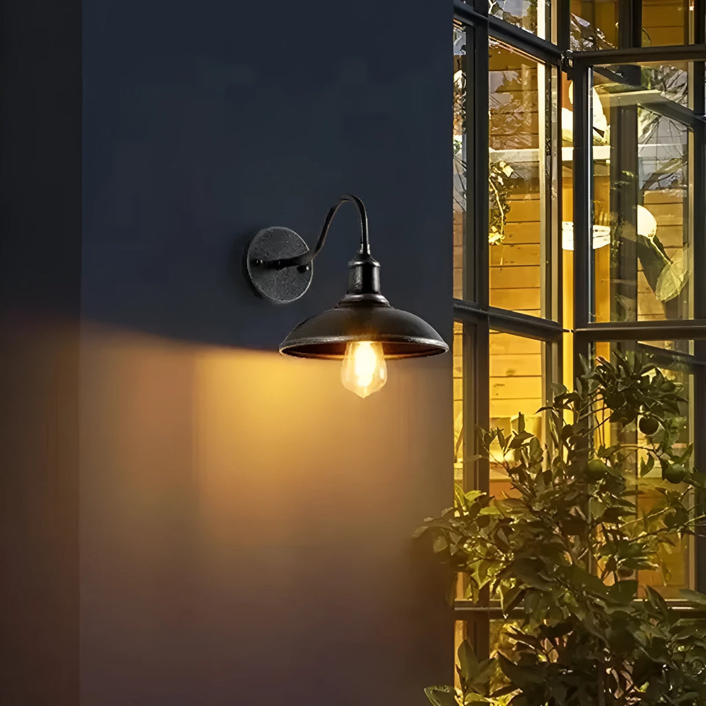 Retro style outdoor wall lamp in a copper finish with an oblique angle mount on a garden wall.