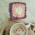 Handmade crocheted wool coaster with Grandmother Lattice pattern in Dream Purple colour.