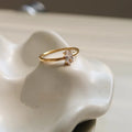 Golden love heart and oval stainless steel ring for women on a white background.