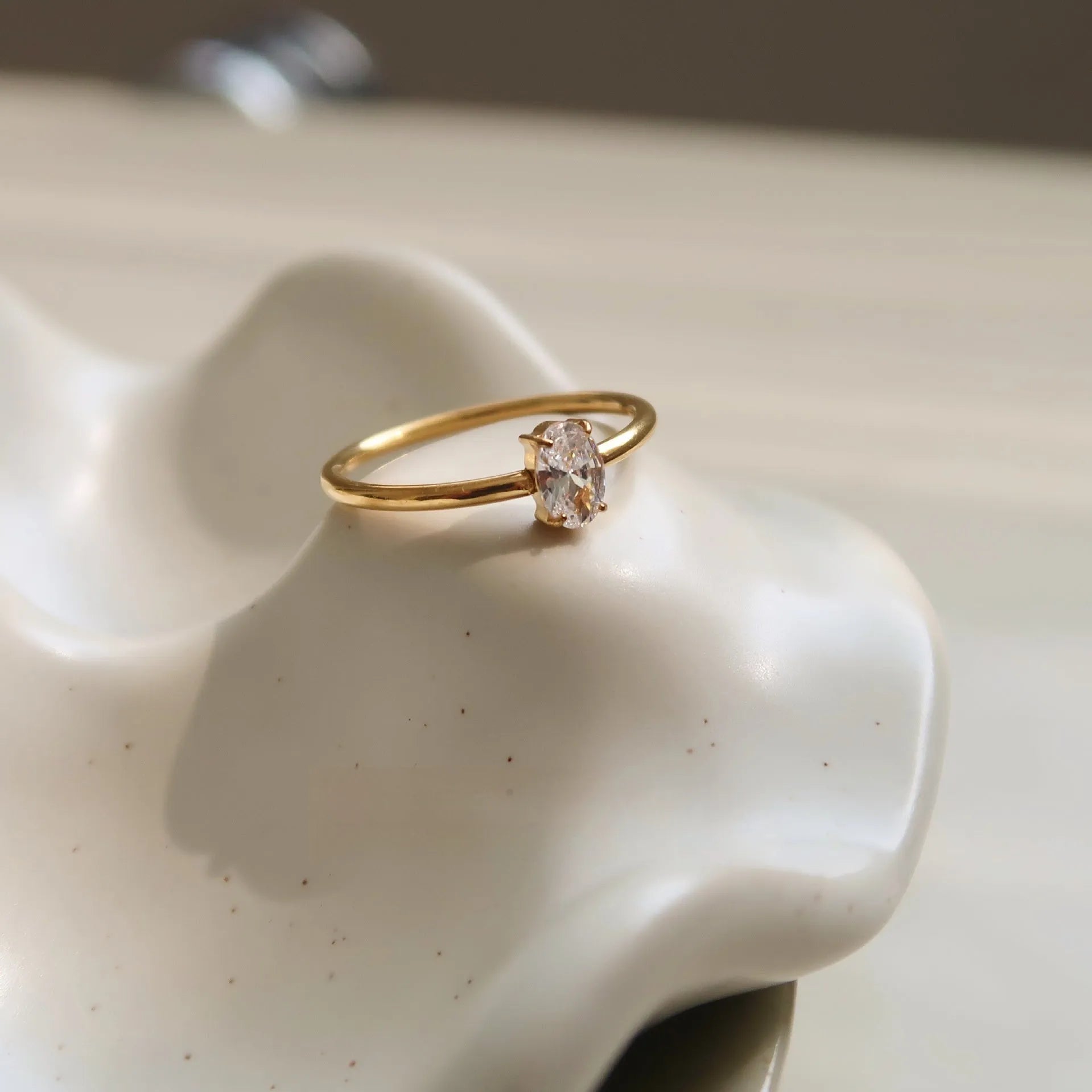 Golden love heart and oval stainless steel ring for women on a white background.