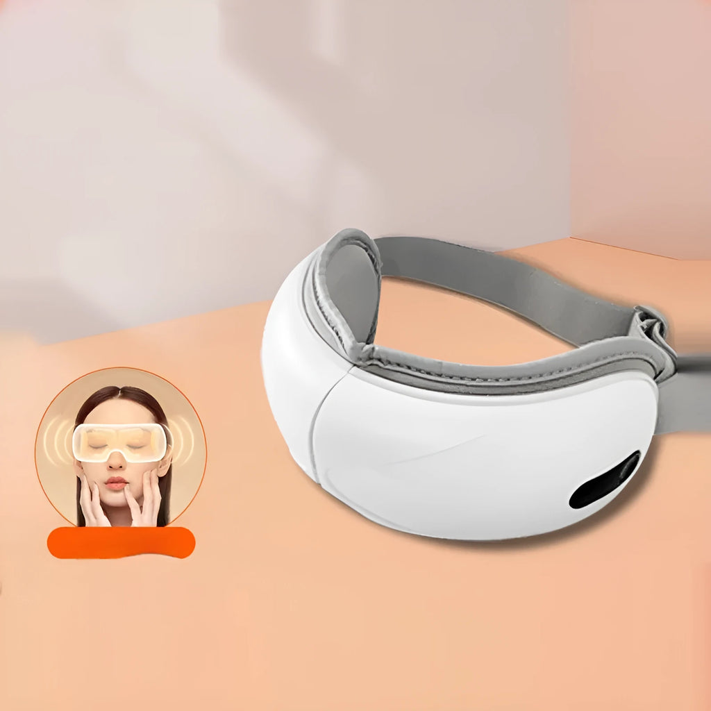 White rechargeable airbag eye massager with heat compress function on a grey background.