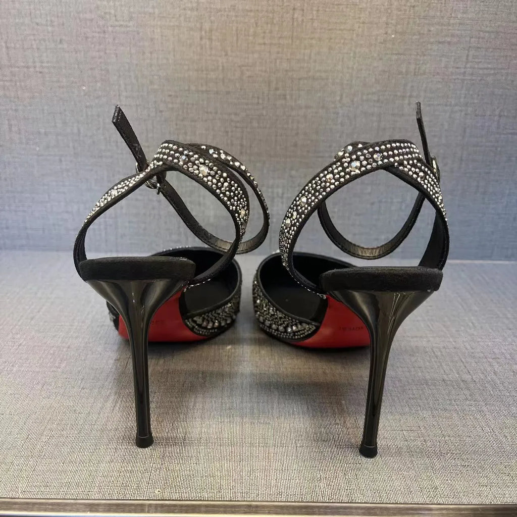 Women's black high heel shoe with a red sole, pointed toe, and a hollow stiletto heel on a plain background.
