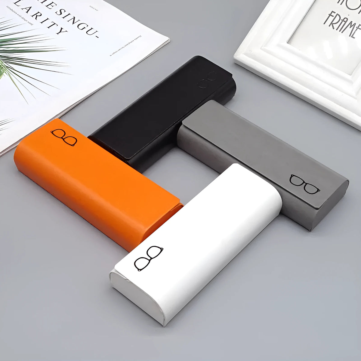 Leather glasses case in black, blue, grey, orange, white, and pink with single compartment for one pair of glasses