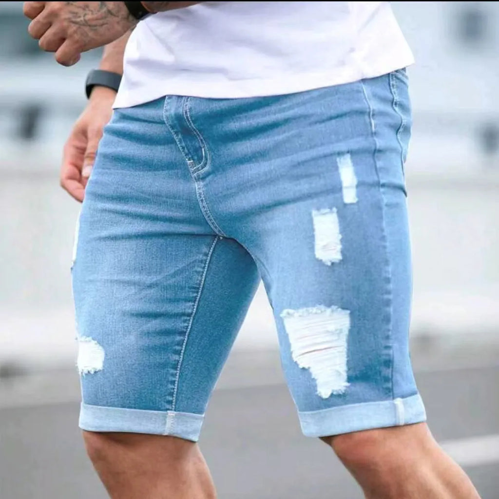Sky blue men's denim shorts with distressed multi-hole detailing and low waist design