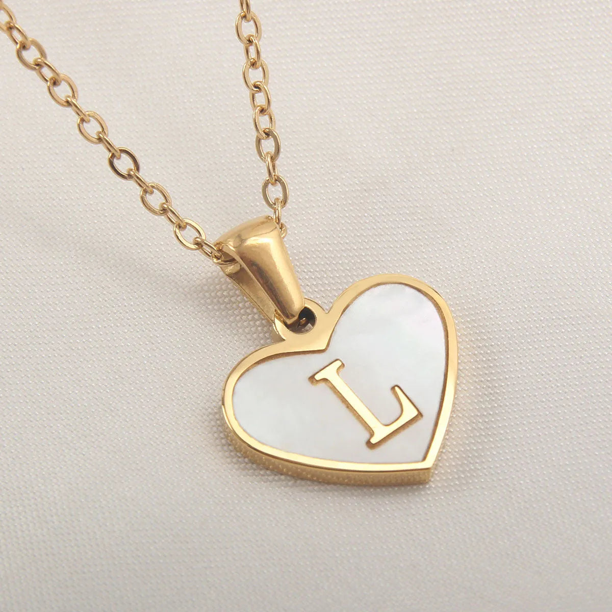 Gold plated chain necklace with a white shell heart-shaped pendant personalised with a single letter initial.