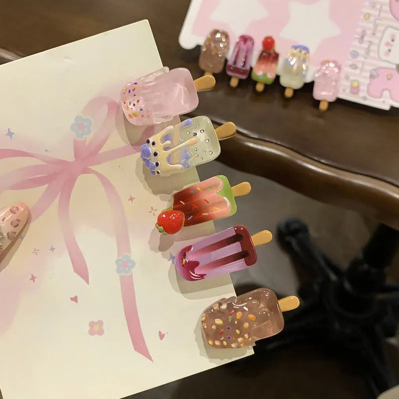 A resin hair clip shaped and coloured like a cartoon ice cream barrette, shown on a side clip.
