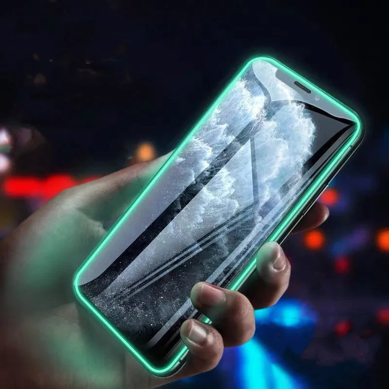 Luminous tempered glass screen protector for iPhone glowing softly in a dark setting.