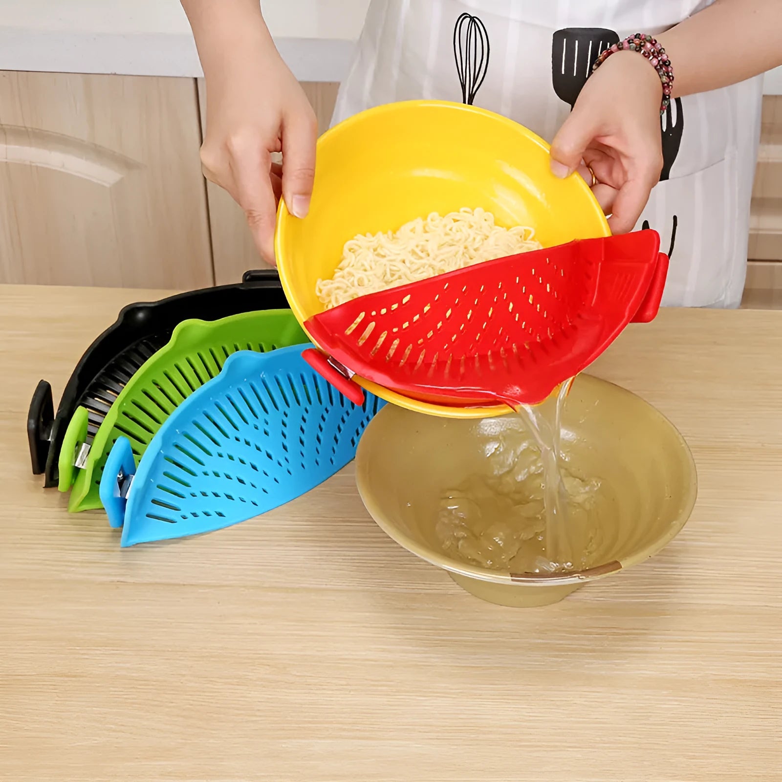 Silicone clip-on kitchen strainer with stainless steel filter mesh attached to a pot rim
