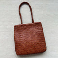 Brown handmade vintage woven leather tote bag with three-dimensional outer pockets.