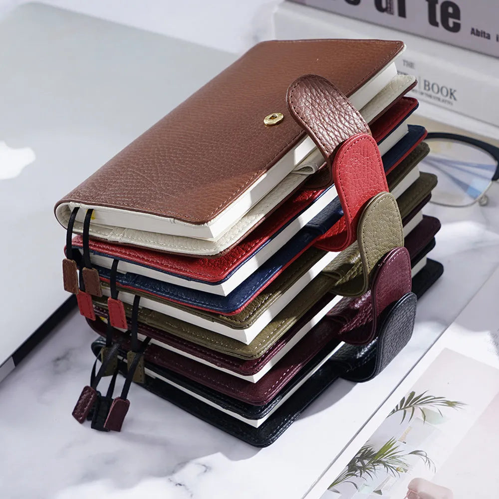 Close-up of a lychee pattern head layer cowhide A6 loose-leaf diary in off white, showing textured cover and ring binding
