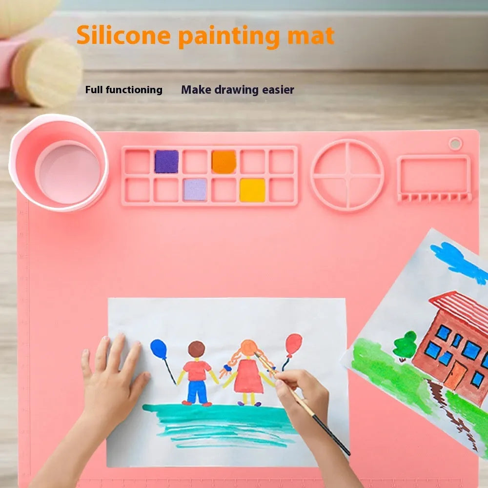 Light blue silicone painting mat with two round bowls, measuring 50cm by 40cm, on a wooden table.