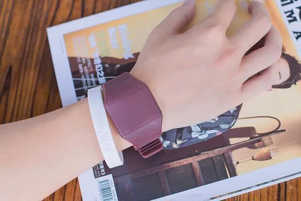Square electronic touch screen watch with plastic case and PU strap on a wrist.