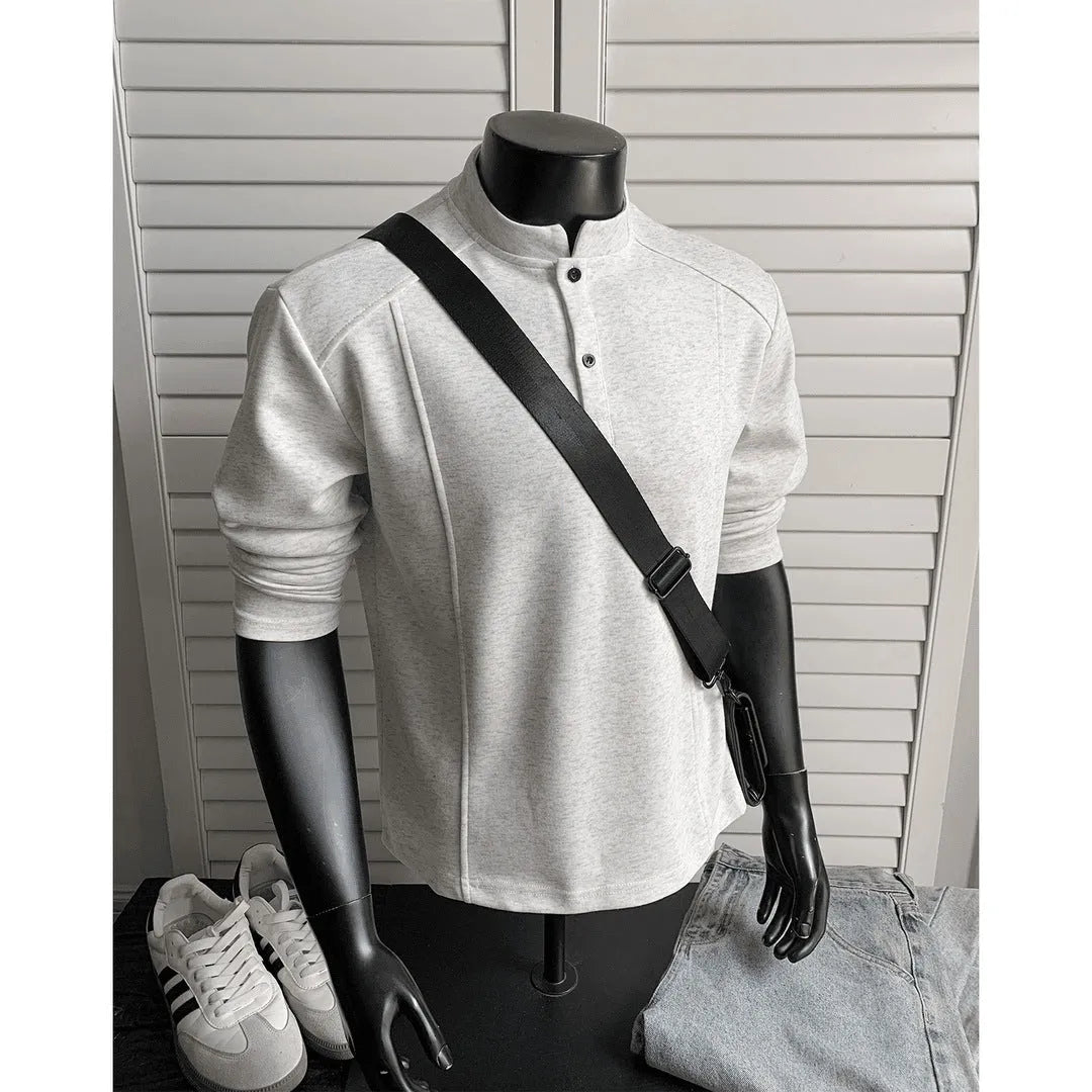 Men's black asymmetric patchwork long sleeve polo shirt with a stand-up collar, laid flat.