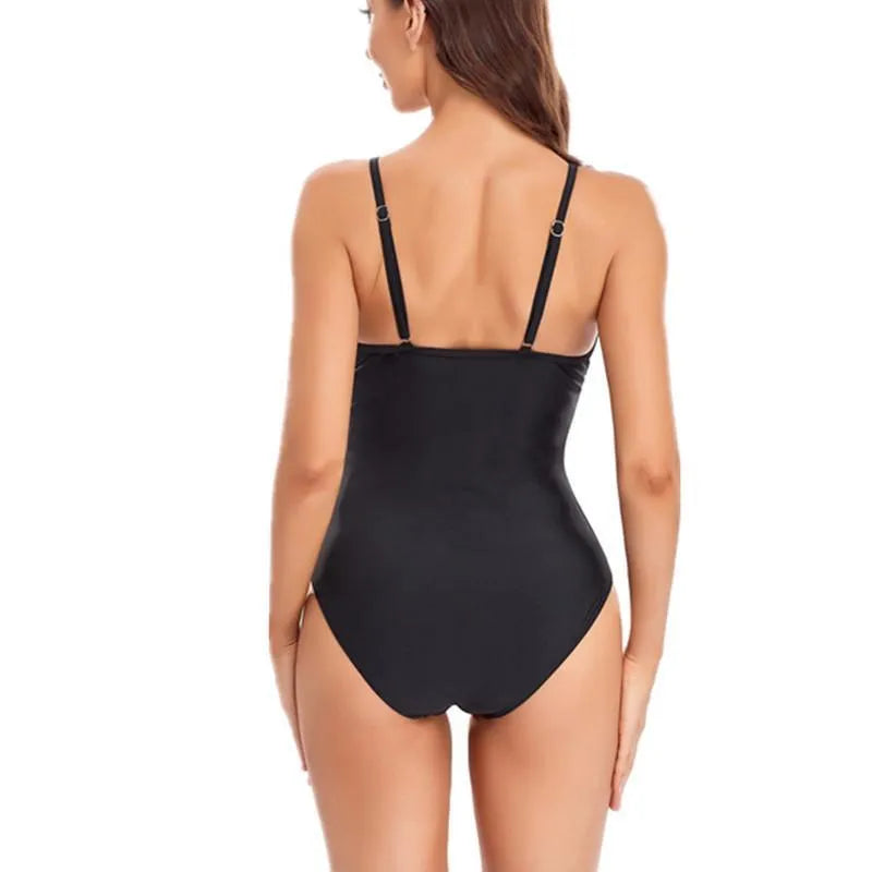 A black one-piece backless swimsuit with a mesh panel detail on a mannequin.