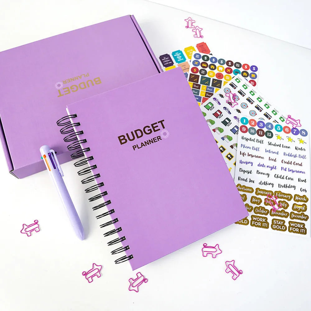 Purple coil-bound financial planning notebook with pen, stickers and paper clips for monthly budgeting