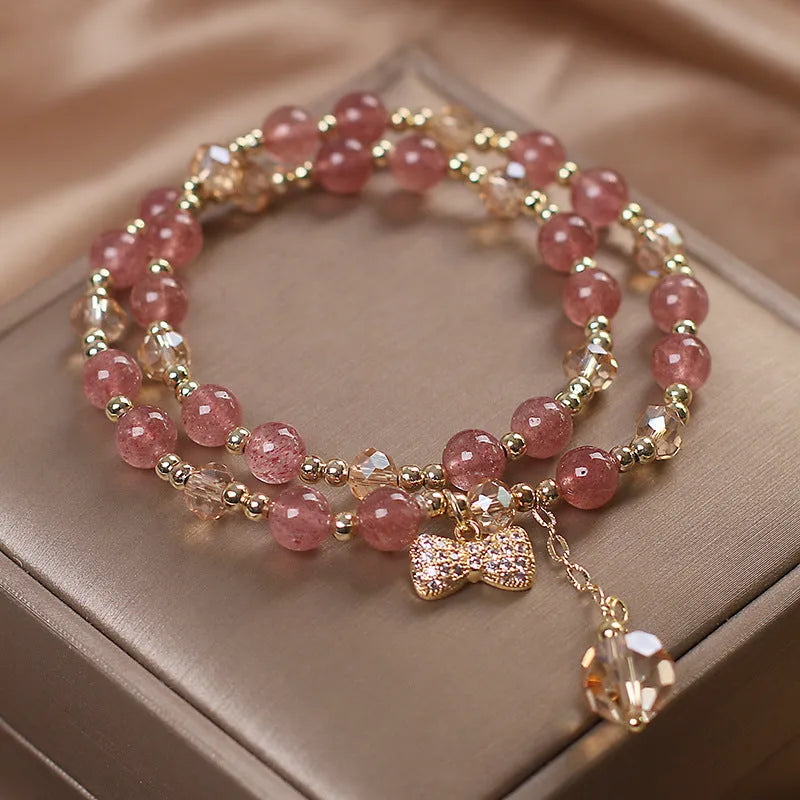 Women's double layer Strawberry Quartz crystal bracelet with Lucky Cat charm and red cat's eye flowers.