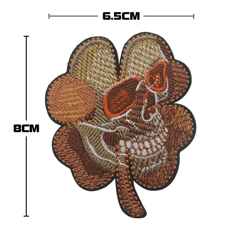 Embroidered fabric badge with Velcro backing showing military-style clover and skull flower designs