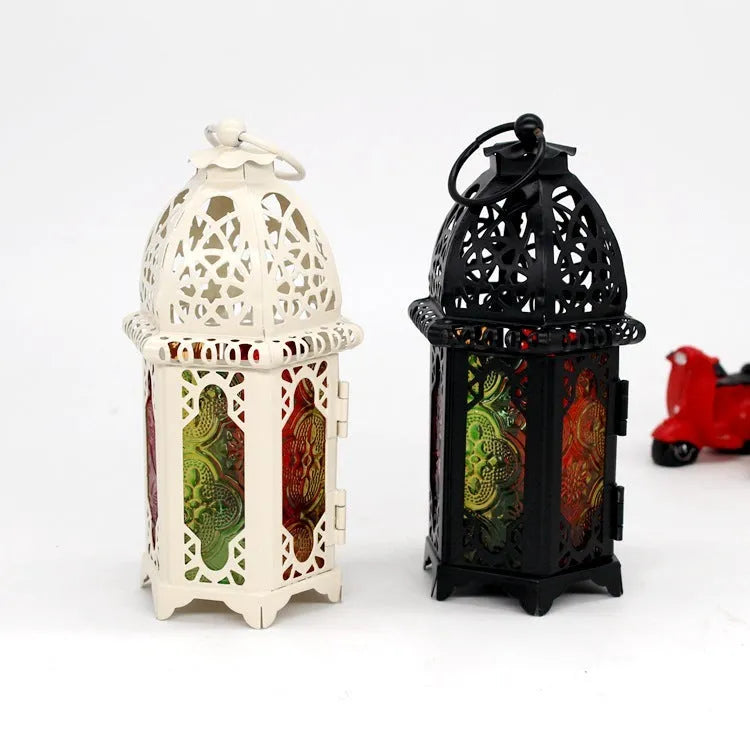 Handmade wrought iron hanging candle holder in black, 16cm tall and 7cm diameter, with a lit candle
