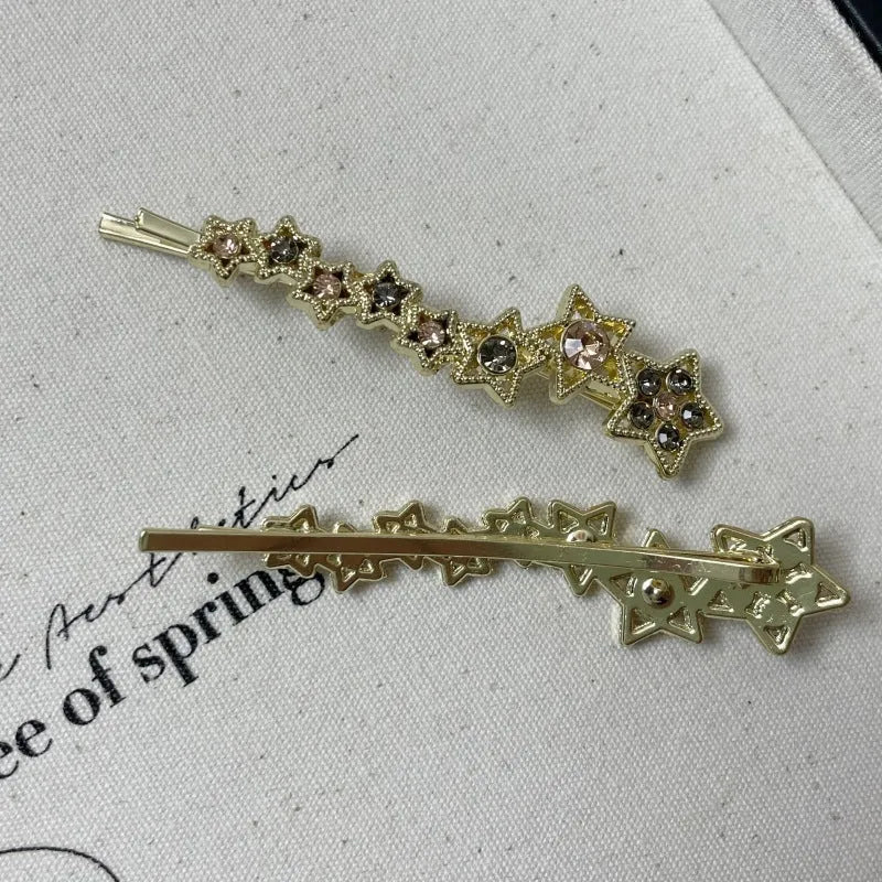Gold-coloured Korean style hair barrette with a star and letter decoration, shown as a side clip for bangs.