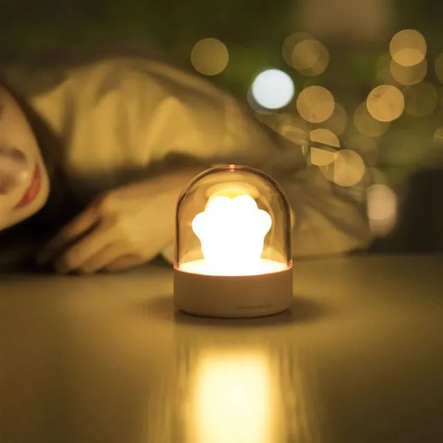 Grey cat paw shaped USB rechargeable night light with music box function on wooden desktop