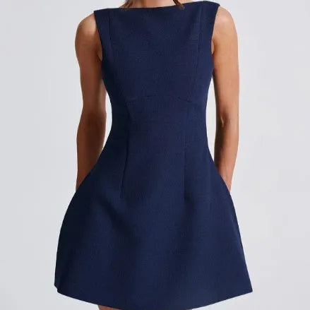 Black backless sling dress with slim fit and short skirt on a model.