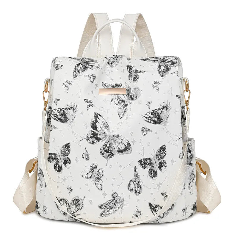 Butterfly print PU leather backpack in purple shown from the side, featuring sewing line details and shoulder straps.