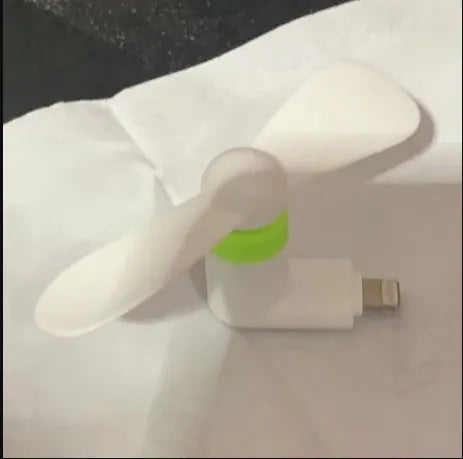 Portable mobile phone mini fan with plastic blades and rotary switch in multiple colours.