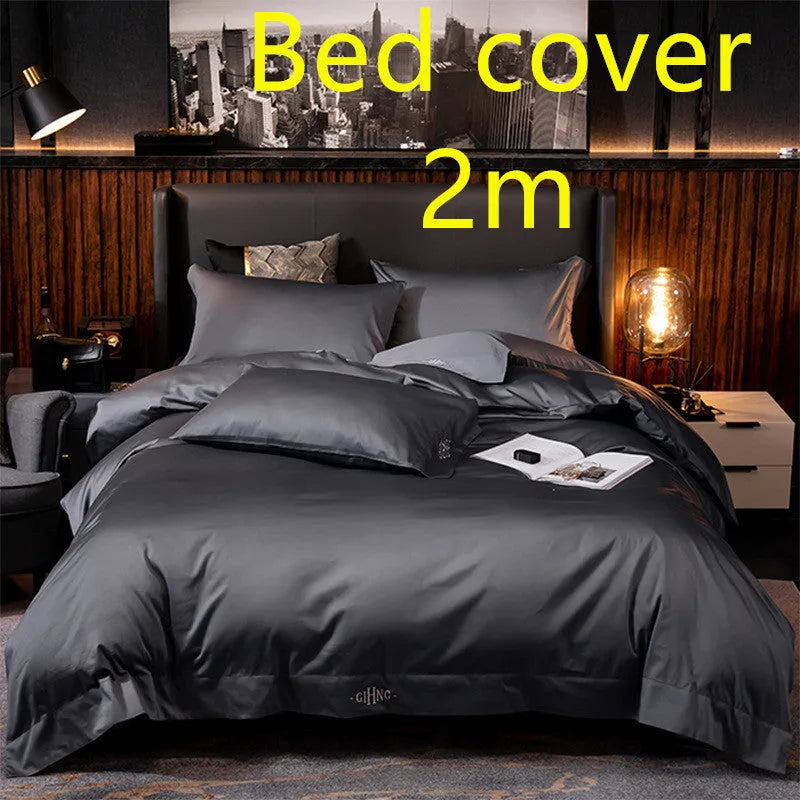 Four-piece cotton satin quilted bedding set with duvet cover, sheet, and pillowcases in a bedroom setting