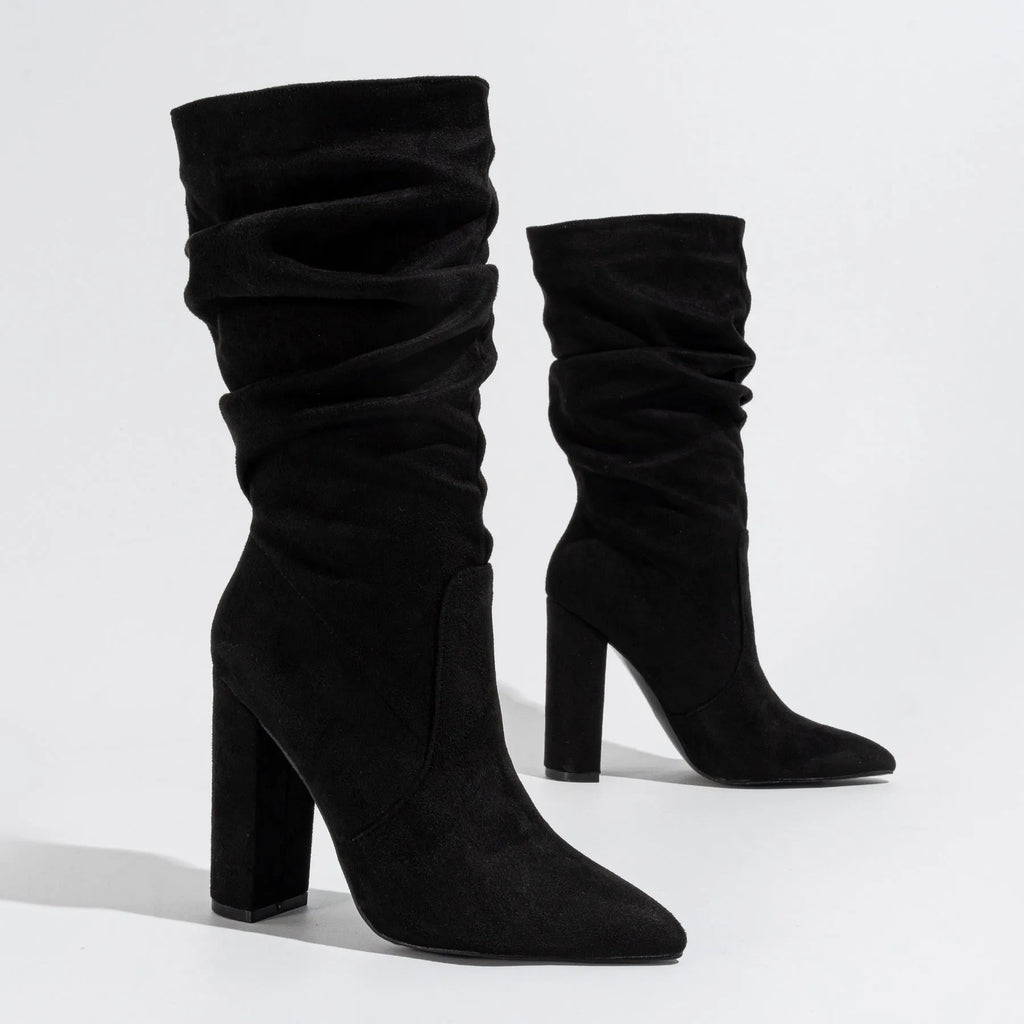 Black suede women's ankle boots with a chunky high heel and pointed toe on a neutral background.