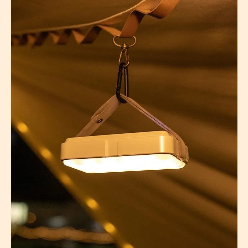 Black outdoor camp light with 10000mAh battery, 40 warm white and 40 white LEDs, IP63 waterproof, shown with hanging accessories.