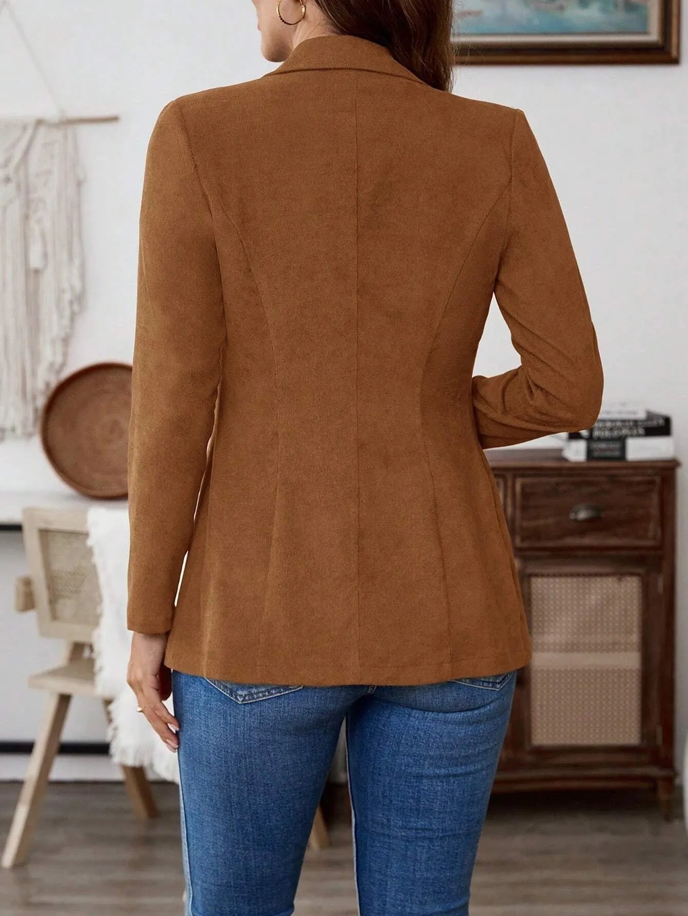 Brown men's single-breasted lapel blazer with long sleeves on a hanger.