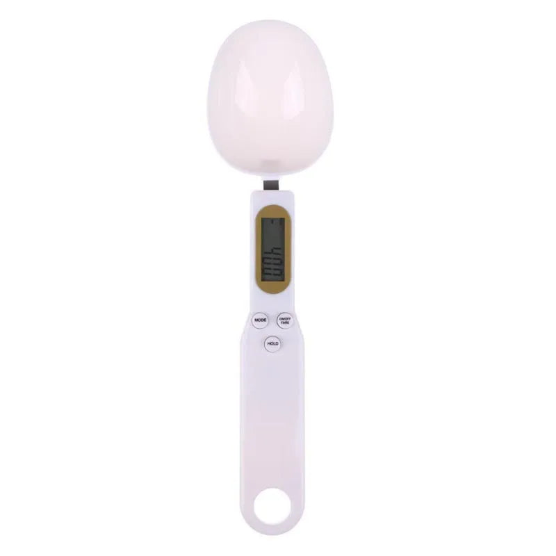 White digital kitchen spoon scale with LCD display showing 0.0g on a wooden table