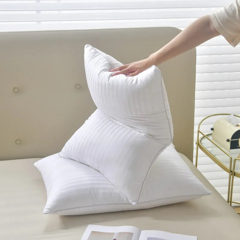 White hotel pillow with a satin stripe on a bed, showing low, medium, and high loft options.