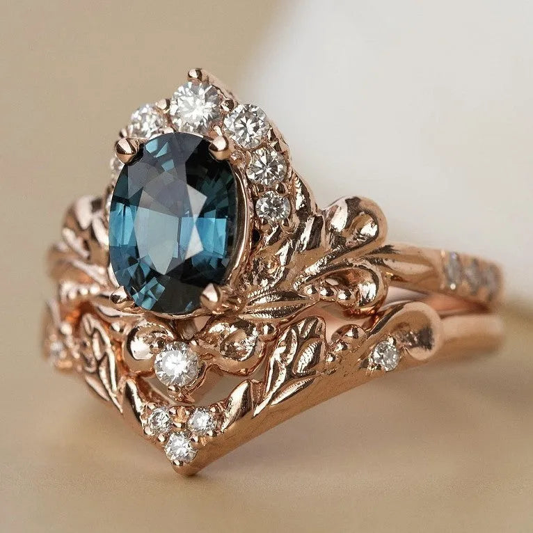 Women's rose gold branch flower ring with inlaid blue crystal, alloy construction, side view on finger