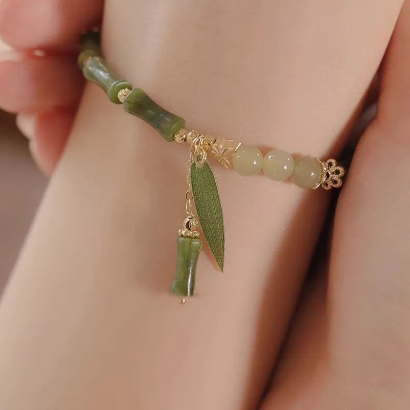 Chinese style glass bead bracelet with bamboo leaf design and manual craftsmanship details.