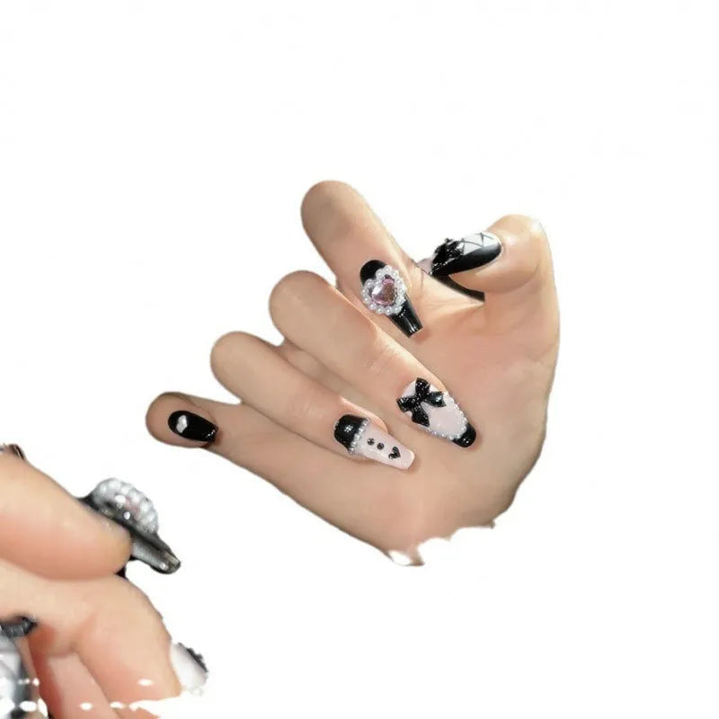Handmade black and pink heart-shaped false nails with Cat's Eye, Bow, and XINGX hand-painted designs.