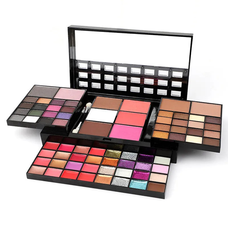 74 colour makeup palette open showing layered powder plates with eyeshadows, lip glosses, blush and contour, with mirror and brushes.