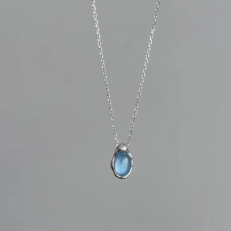 Navy blue water drop necklace with platinum accents on adjustable cross chain
