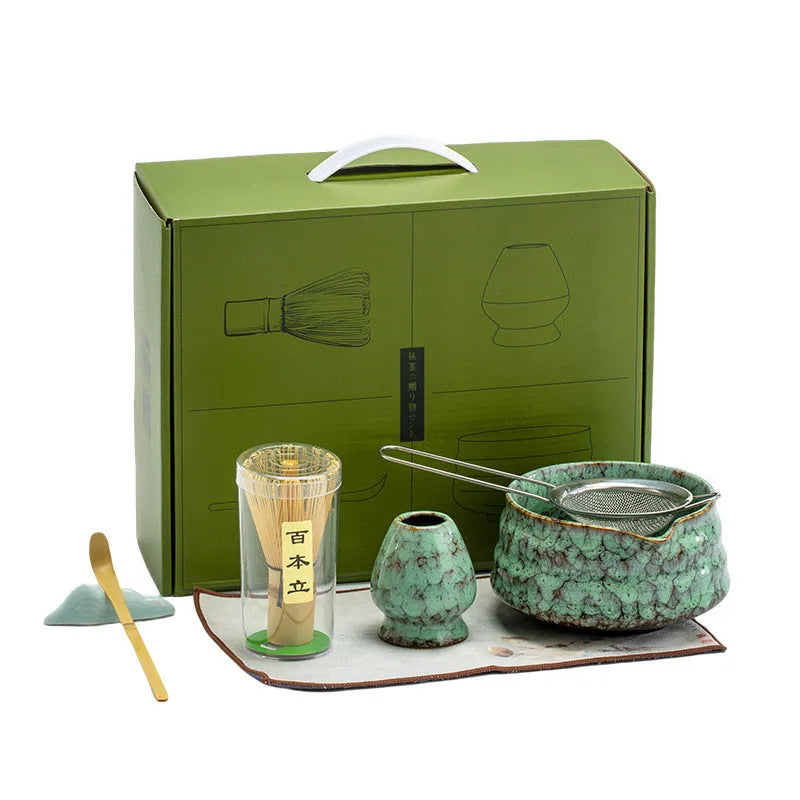 Seven-piece Japanese style matcha set with ceramic bowl, bamboo whisk, stand, tea tray, filter screen, and tea towel in gift box
