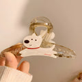 Cartoon puppy design hair barrette clip in beige and brown colours on a white background.