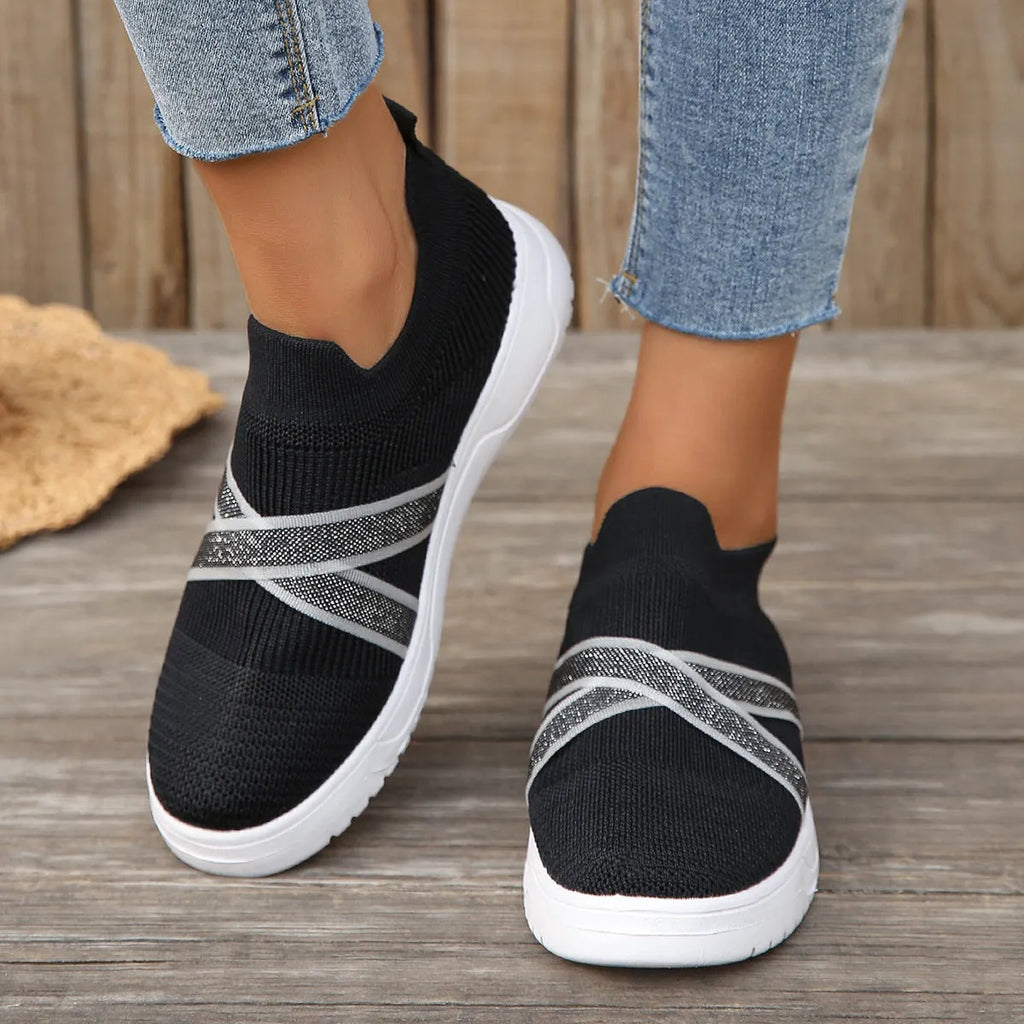 Black women's low-top casual shoes with Flyknit mesh fabric and a flat rubber sole.