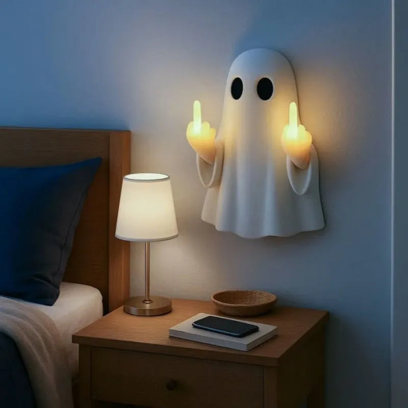 Small white ghost statue night lamp on a shelf for Halloween decor.