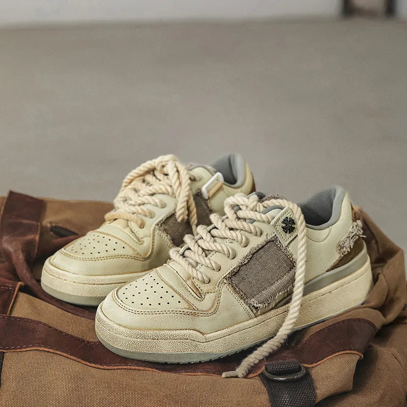 Beige vintage style low top skateboard shoes with flat rubber sole and lace-up front.